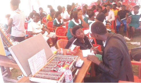 Dr Felix Awuriki (right) interacting with one of the students during the health screening at JAPASS